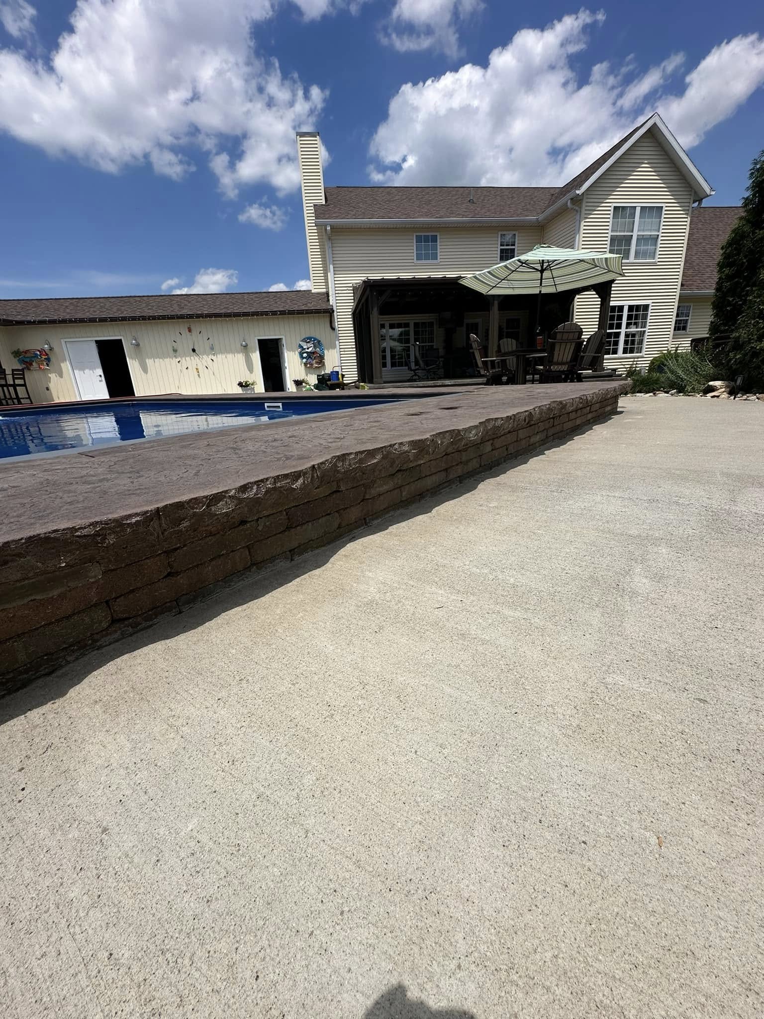 Concrete pool deck with retaining wall